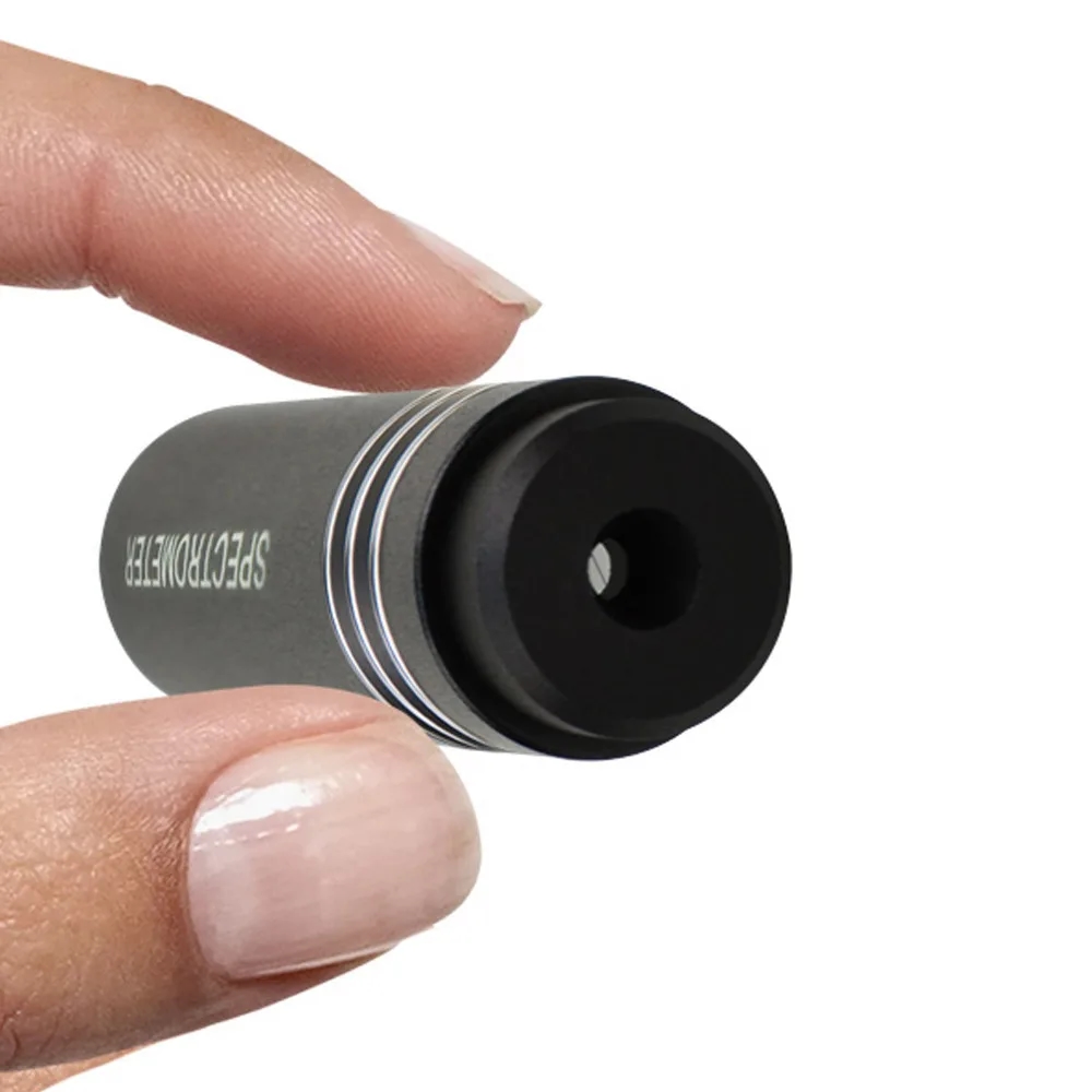 The spectroscope is directed at a precious stone for its optical evaluation