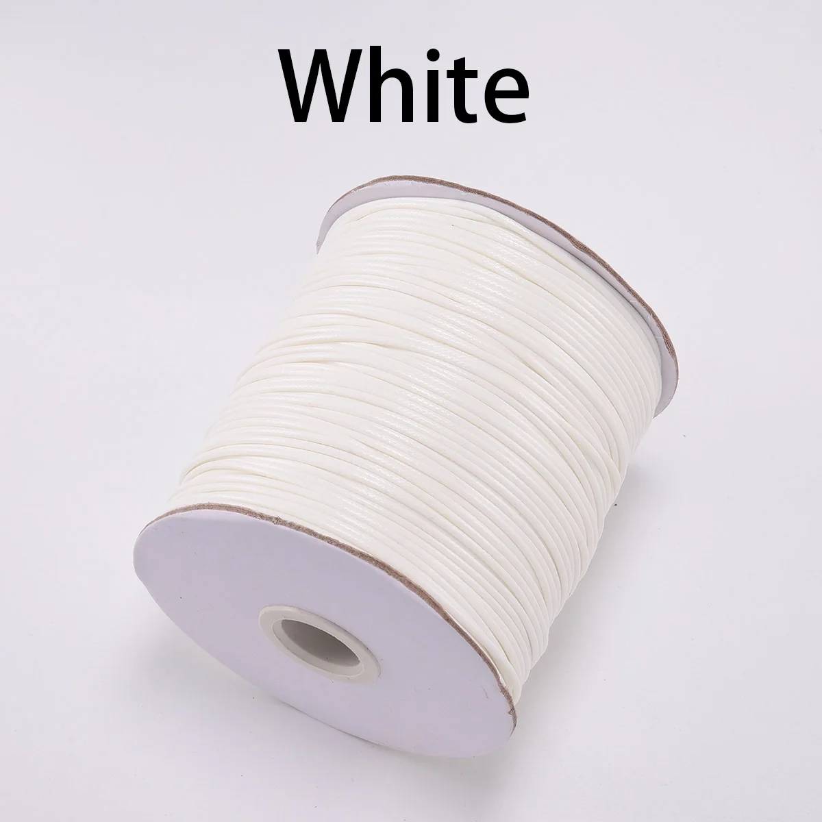 Spools with waxed cotton cord in blue, black, brown and red colors