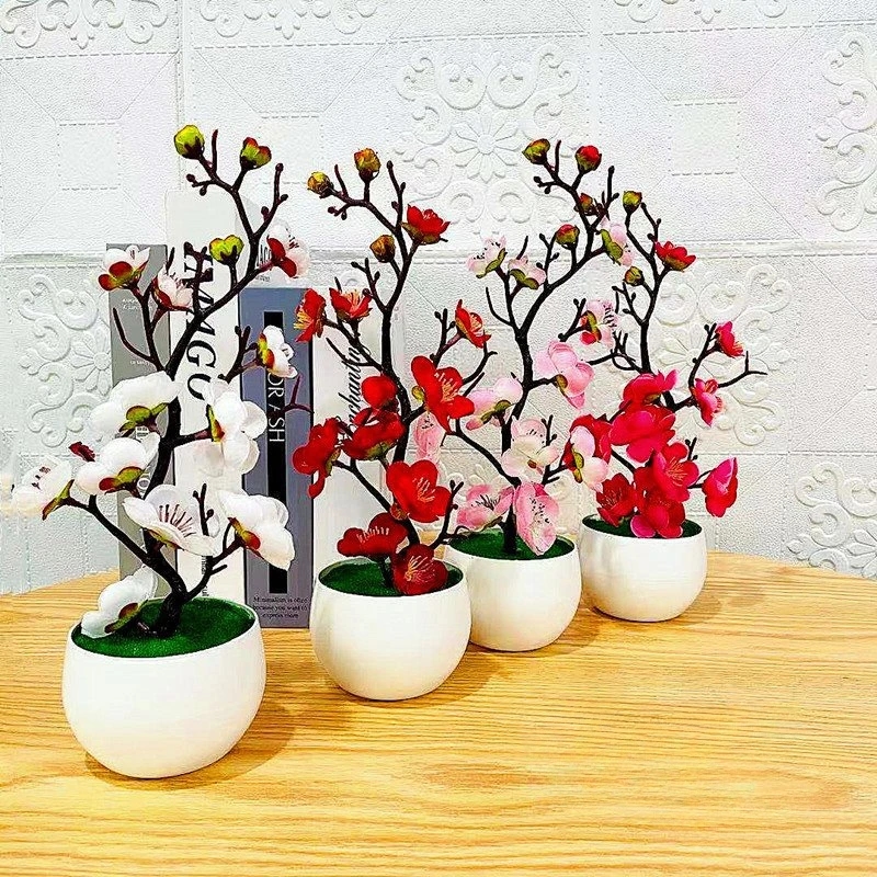 Miniature artificial bonsai plant with pink flowers in a ceramic pot