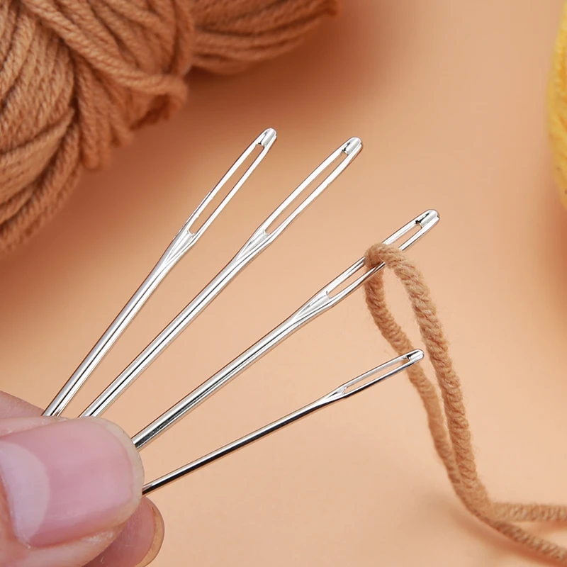 Set of needles for embroidery, sewing and knitting, lying on a white surface