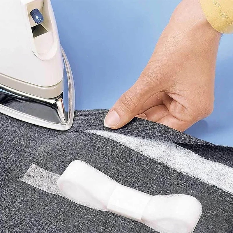 Une personne utilise un ruban adhésif pour ajuster la longueur d'un jean à sa taille