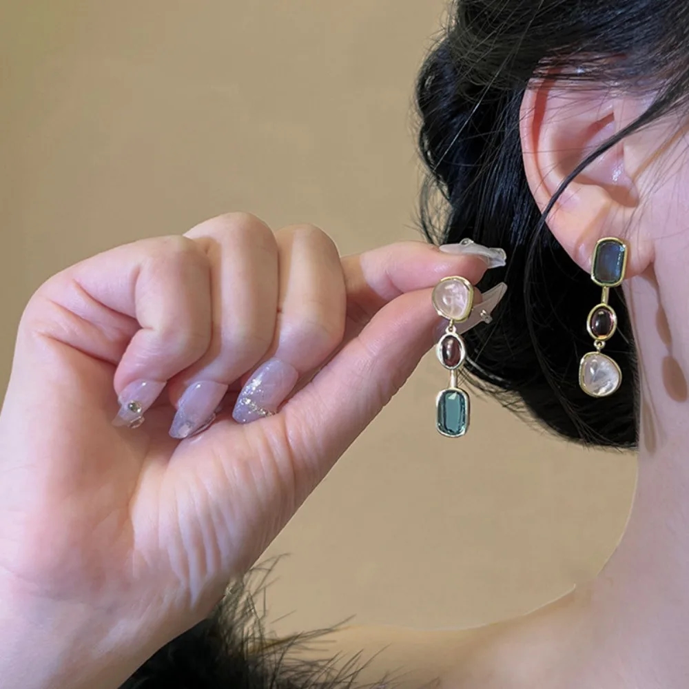Close-up of multicolored inserts in asymmetric earrings