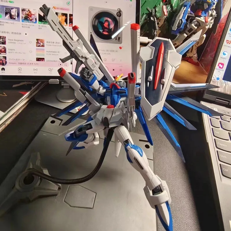 Robotermodellfigur Mecha Flying Freedom HG 1/144 SEEDFREEDMO neben anderen Gegenständen zur Demonstration des Maßstabs