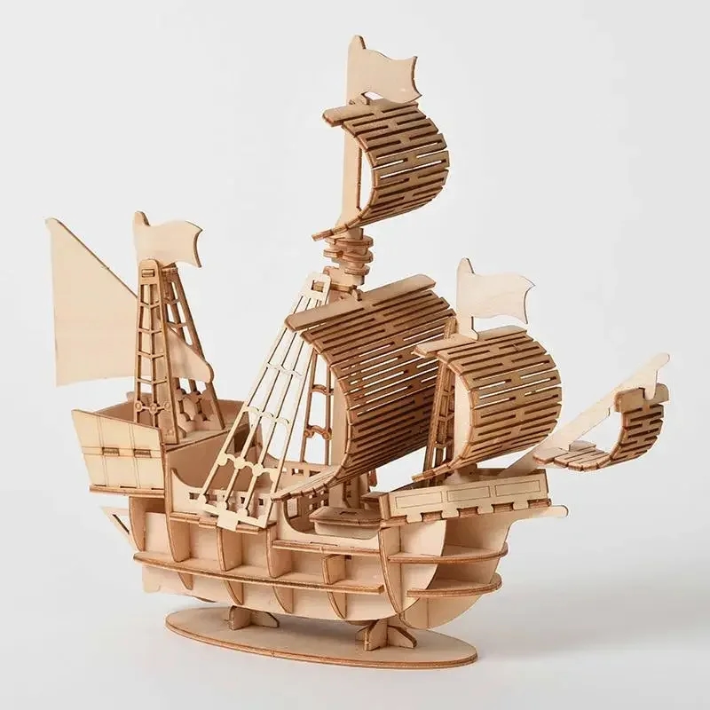 Nahaufnahme eines fertig gebauten Holzsegelfiffs auf einem Tisch mit verstreuten Teilen