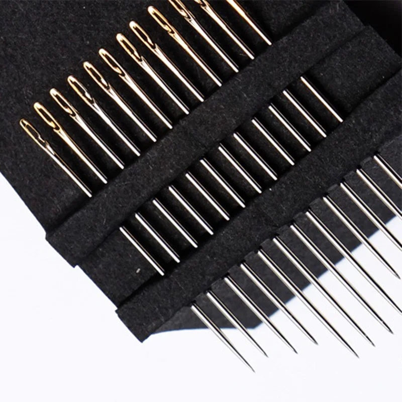 Many sewing needles for hand sewing, laid out on a table