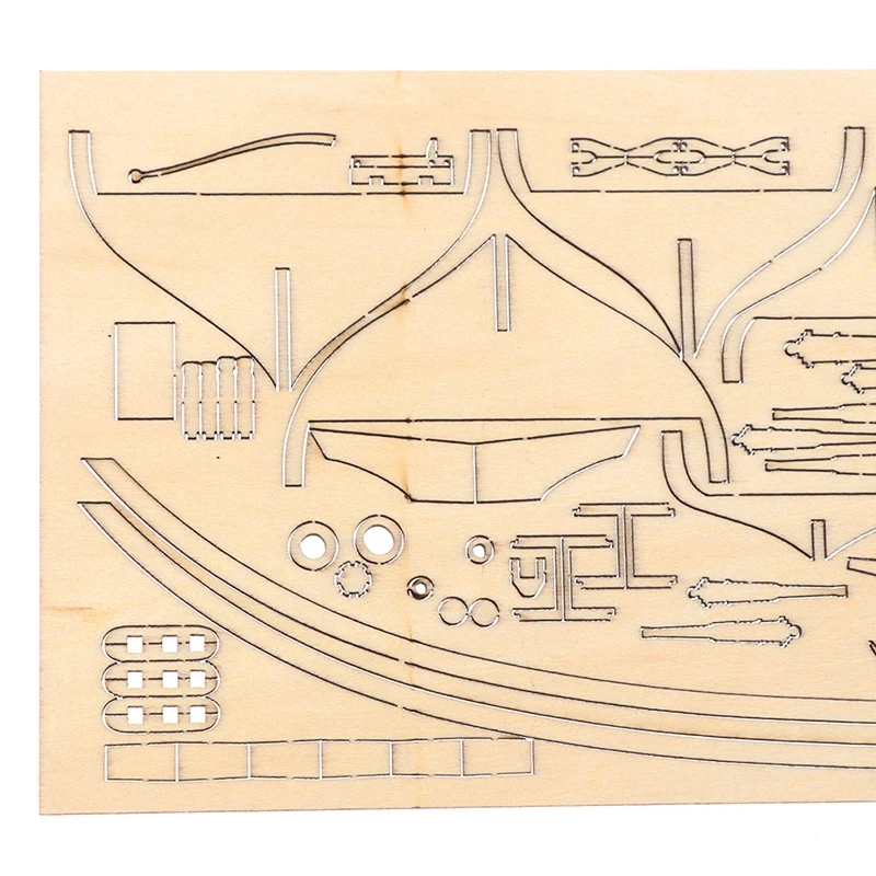 A person assembling the parts of a wooden model of a sailing ship