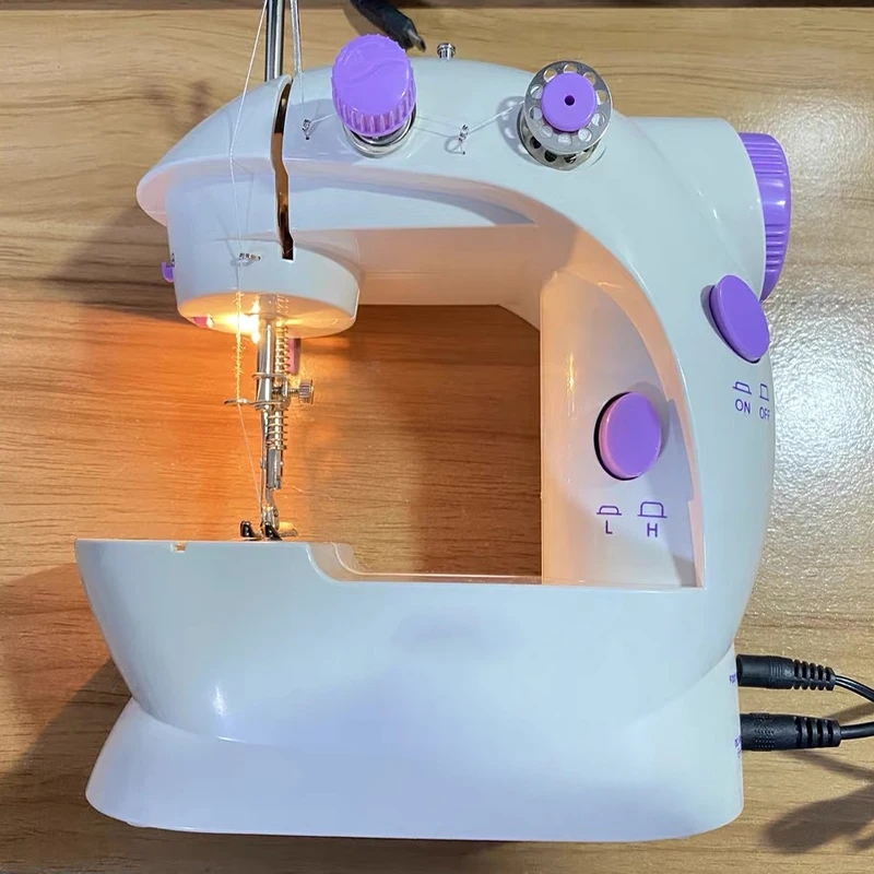 Petit tissu sous l'aiguille de la mini machine à coudre, montrant sa compacité et sa fonctionnalité