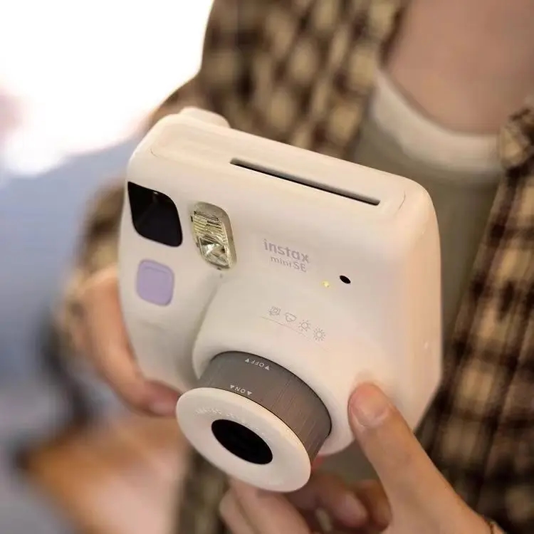 Câmera Instax Mini SE em uma mesa festiva entre presentes