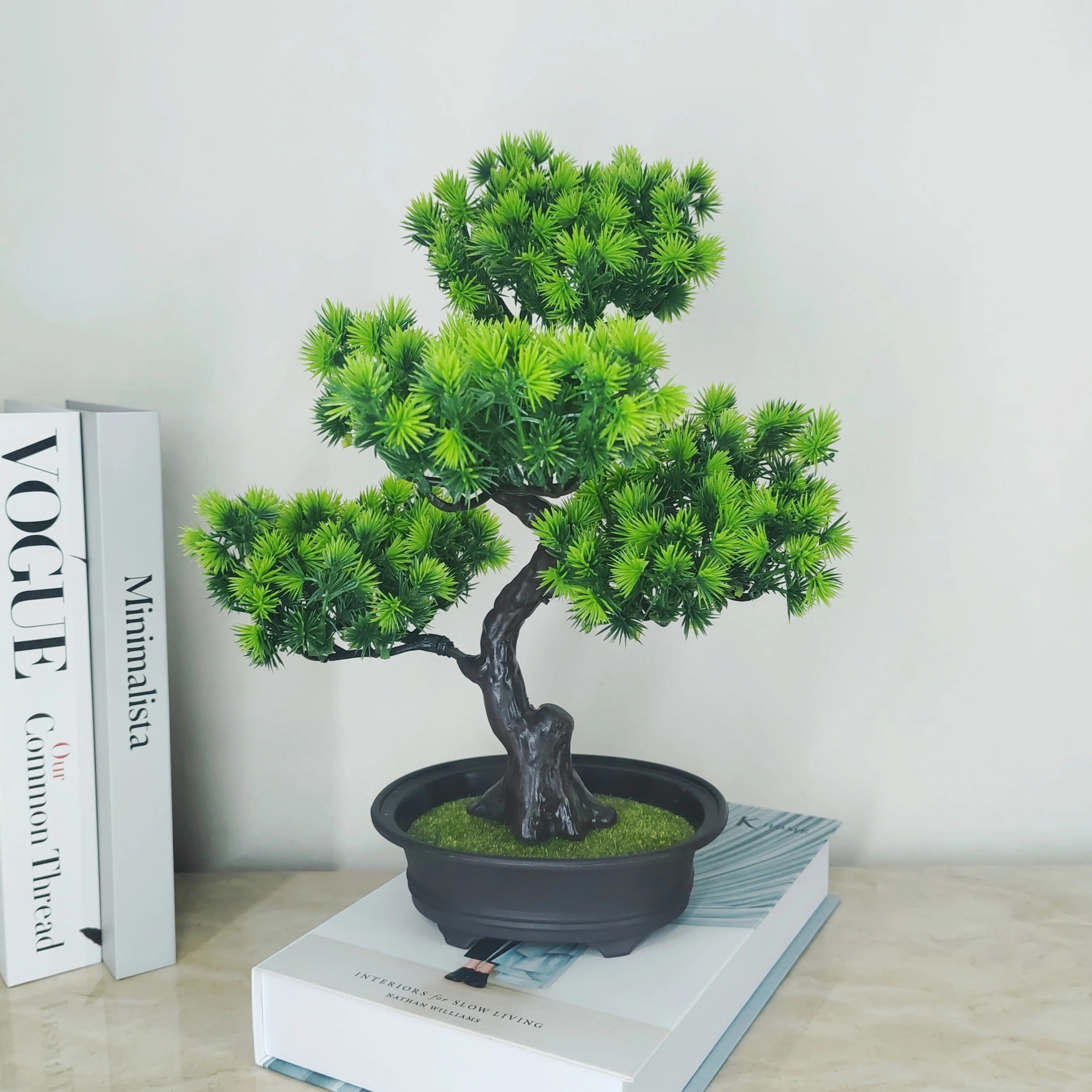 Árbol bonsái artificial elegante en la mesa, creando un ambiente acogedor