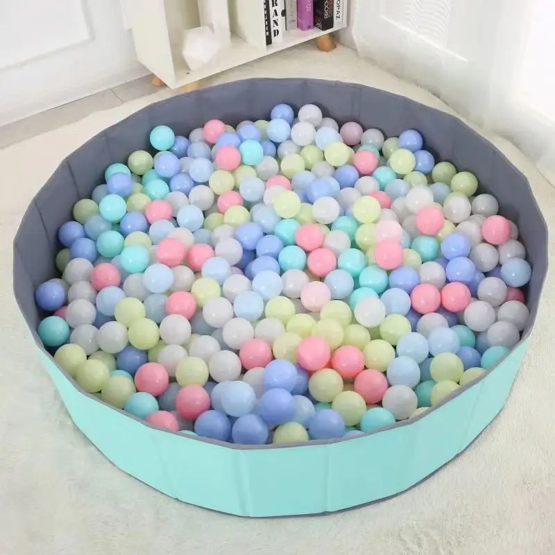 Children's hands holding several multicolored plastic balls