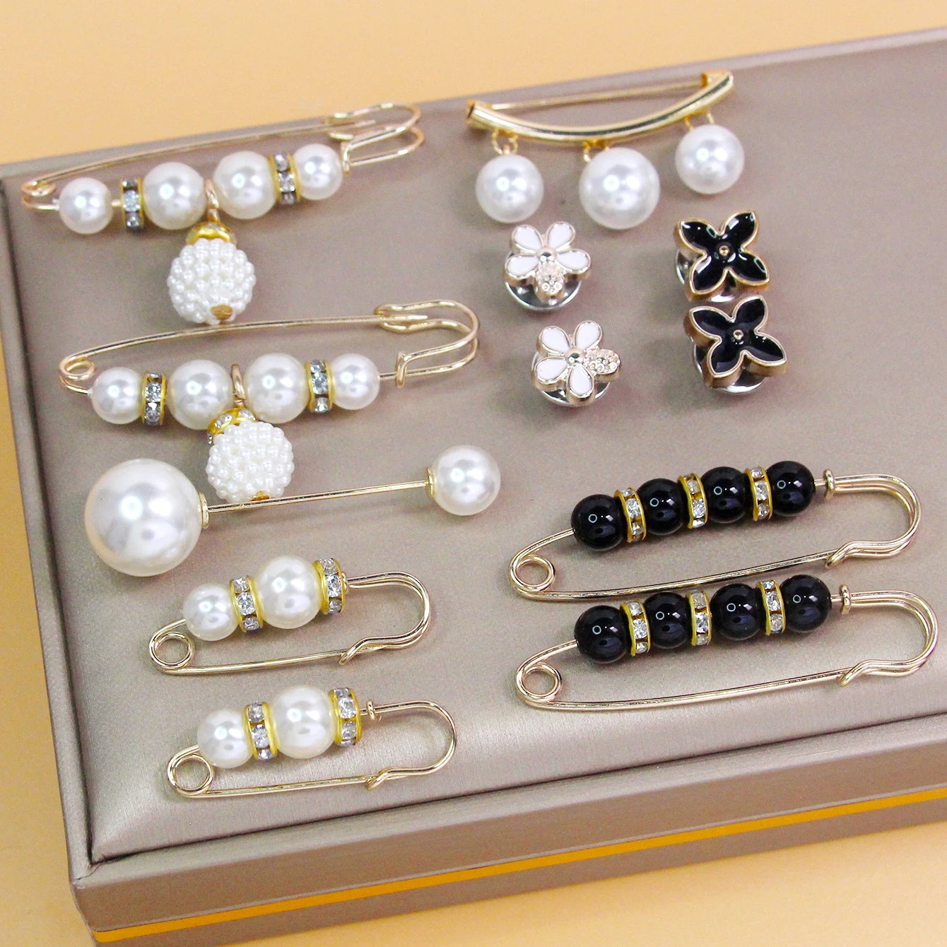 Colorful metal brooch with pearls in the form of a geometric pattern