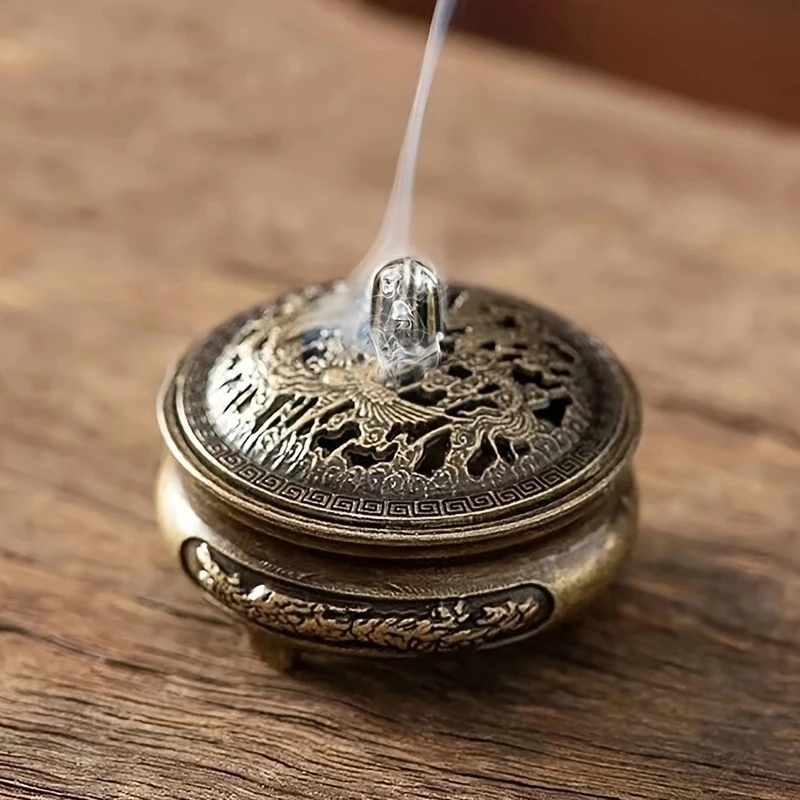 Miniature bronze incense burner against the background of a tea set